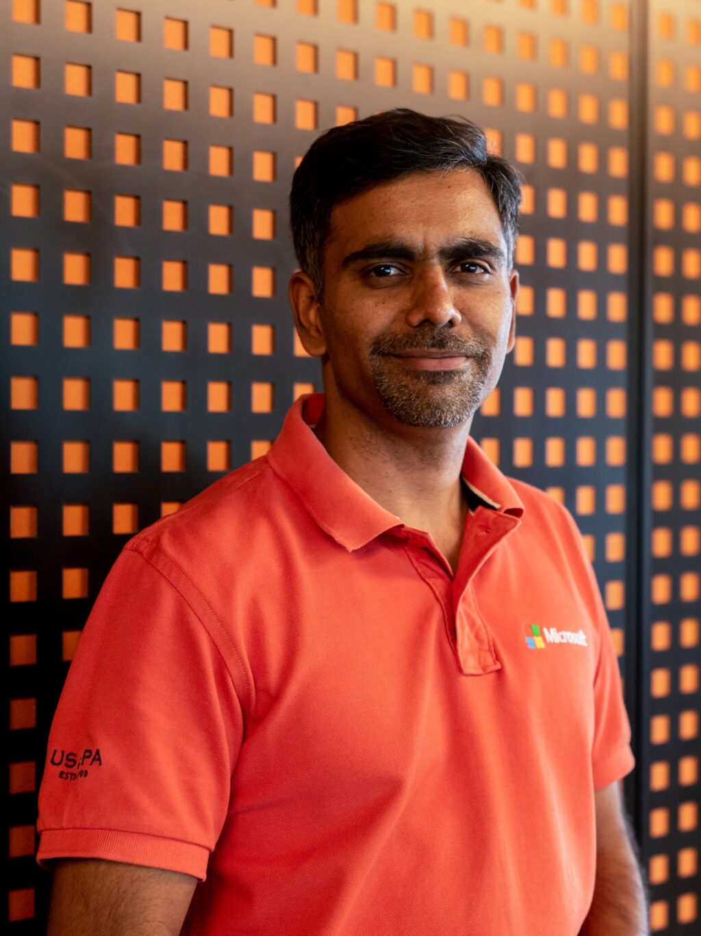 a man wearing an orange t-shirt looking at the camera