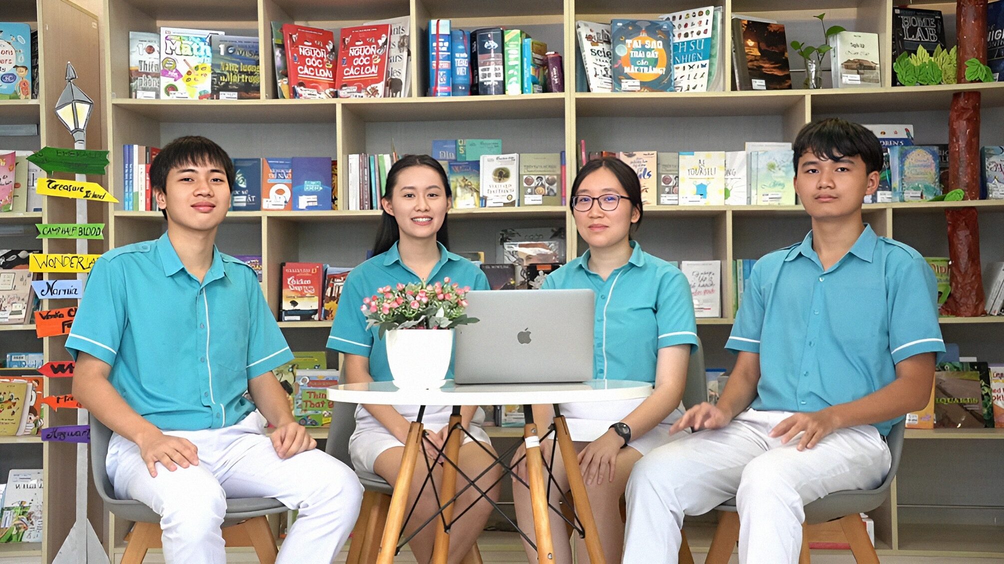4 members, two boys and two girls, of the winner sitting in the school library