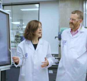 Two people in lab coats in a lab