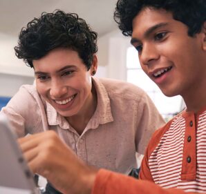 Two young boys (students) looking at a laptop