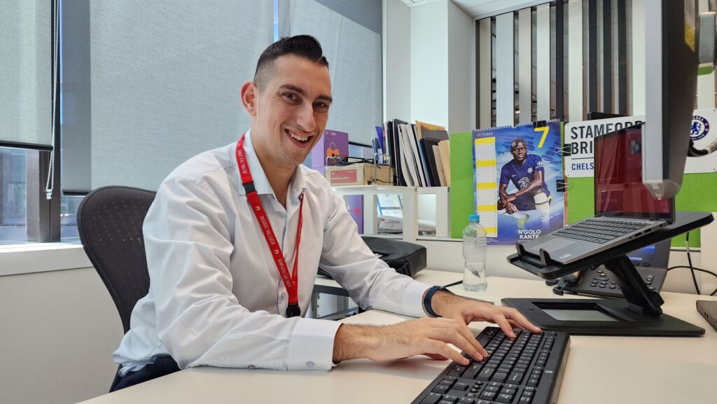 Anthony Moufarrege wearing a white shirt working at a computer. 