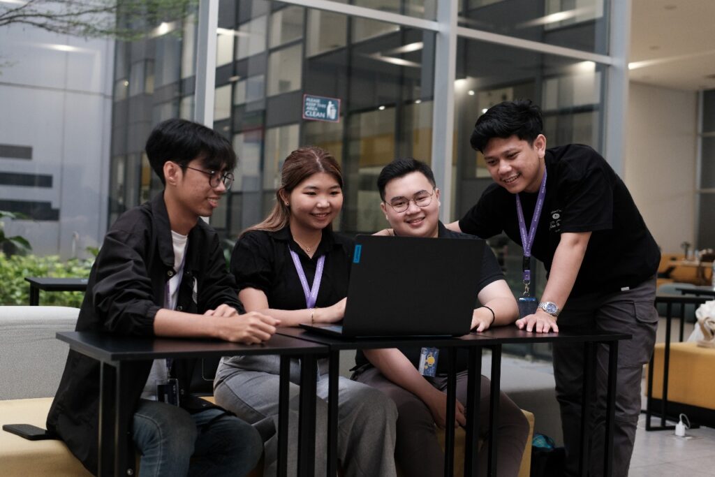 4 Binus students looking at laptop